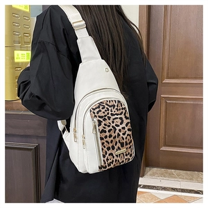 Detail of leopard print crossbody bag with multiple zippers and adjustable fabric strap