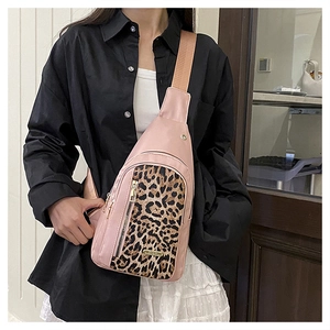 Detail of pink crossbody chest bag with leopard print accent and metallic zipper on model