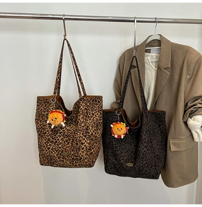 Dettaglio di borse tote leopardate con ciondoli burger su completi dai toni della terra