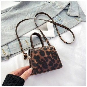 Close-up of leopard print mini crossbody bag with golden hardware and textured finish