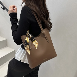 Brown leather tote bag with silk scarf decoration and adjustable shoulder strap