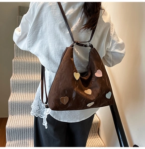 Detail of vintage brown leather backpack with colorful heart patches on the back