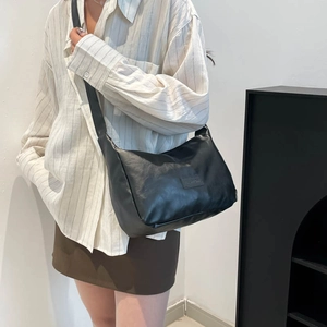 Minimalist black oil wax leather large tote bag shown on a model for daily commute
