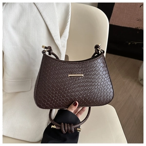 Detailed close-up of the woven leather texture and gold hardware on dark brown bag