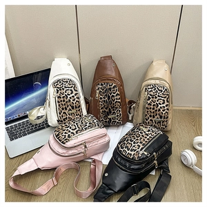 Detailed flat lay of five leopard print crossbody bags in various colors on a wooden desk