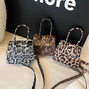 Three leopard print mini handbags in black, dark brown, and light tan with gold hardware