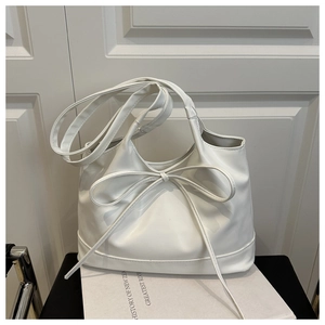 Détail du nœud décoratif blanc et du cuir ciré lisse sur ce grand sac cabas fourre-tout