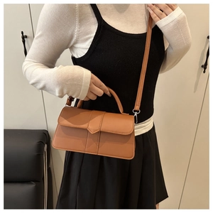 Detail showing the brown faux leather square bag with top handle and detachable strap
