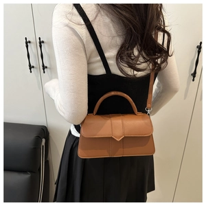 Rear view of model wearing a brown vintage leather crossbody bag with top handle