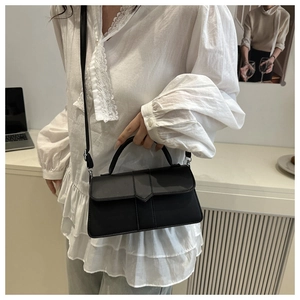 Modern black crossbody bag styled in a casual home setting for everyday commute