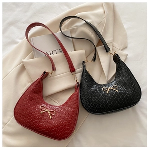 Detailed close-up of woven texture and golden bow buckle on burgundy and black hobo bags