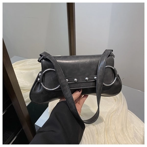 Détail du sac baguette noir avec grands anneaux argentés et rivets style punk