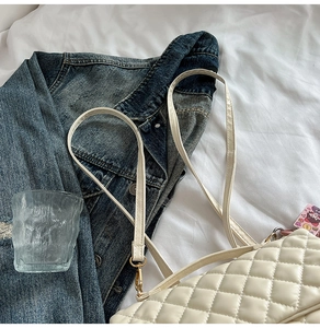 Classic quilted diamond pattern tote bag in cream white shown on cozy fabric setting