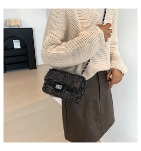 Détail du sac bandoulière en tweed gris avec texture effilochée et fermoir rotatif argenté