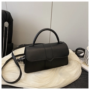 Detail view of the black matte square bag with V-shaped flap and silver hardware