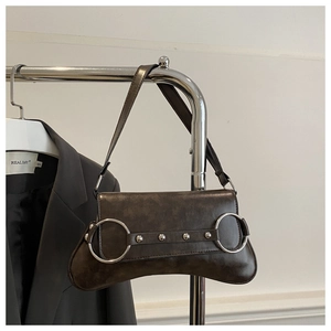 Détail du sac bandoulière rétro marron foncé avec anneaux argentés et rivets