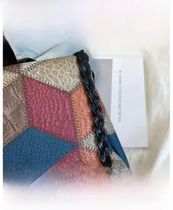 Close-up of geometric patchwork leather with crocodile and lychee textures on a tote