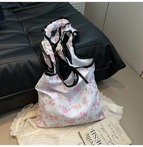 Floral canvas tote bag with black ruffled edges and pink flower print detail