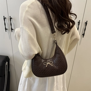 French style dark brown woven hobo bag with gold bow knot accessory worn on shoulder
