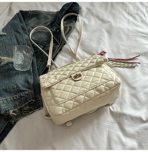 Close-up of cream quilted tote bag with golden twist lock and soft leather texture