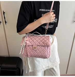 Detail of pink quilted crossbody bag with gold twist lock and cute plush charm