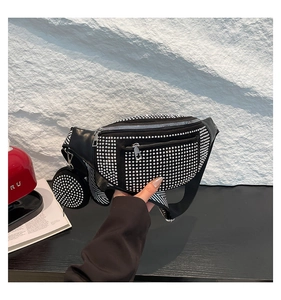 Close-up of black rivet waist bag with geometric strap and matching small round pouch