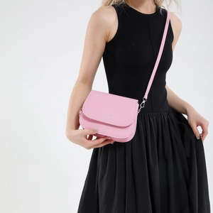 Pink leather saddle crossbody bag for women with silver logo and adjustable strap
