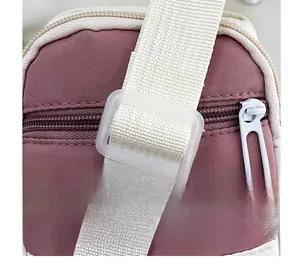Detail view of pink fabric bag showing adjustable white strap and plastic buckle