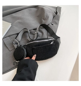 Detail of black studded waist bag with chevron strap and small round coin purse attachment