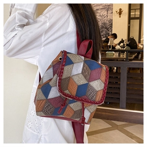 Detail of colorful patchwork leather bag with woven edges and unique geometric pattern