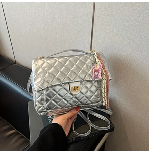 Detailed view of silver quilted tote bag with metallic texture and rotary lock clasp