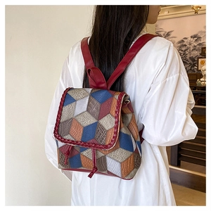 Detail of color-block geometric pattern backpack worn by model in a home setting