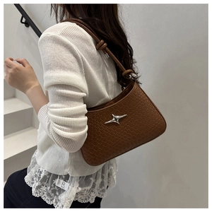 Détail du sac hobo marron foncé avec texture tressée et ornement en métal étoile argentée