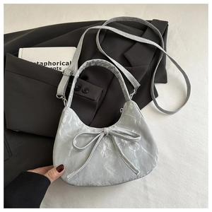 Close-up of metallic texture and bow detail on the silver hobo shoulder handbag