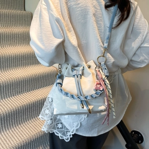 Chic color-block bucket bag with woven handle and drawstring closure shown on model