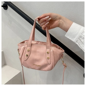 Détail de la texture en similicuir rose avec lettrage doré et rivets métalliques