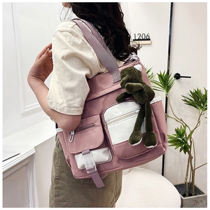 Detailed side view of pink nylon tote with large capacity and green frog charm