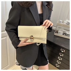 Detailed view of the creamy white horizontal grain texture and gold geometric buckle clasp