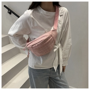 Sac bandoulière à carreaux rose porté par un mannequin avec bandoulière réglable