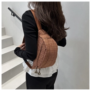 Détail du sac bandoulière en tweed marron avec motif de surpiqûres blanches quadrillées