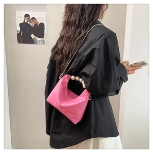 Detail of rose pink hobo bag with round pearl handle and slim metal chain strap