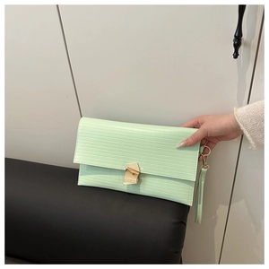 Detail of mint green wave texture leather envelope bag with golden geometric clasp