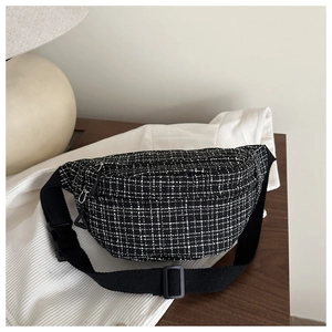 Vue détaillée du sac de poitrine en tweed à carreaux noir et blanc sur une table en bois