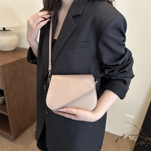 Minimalist beige crossbody bag with fashion trend text and elegant flap closure