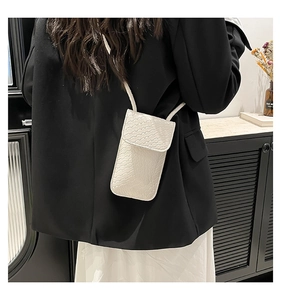 Close-up van de witte geweven telefoon crossbodytas met een getextureerd klepontwerp