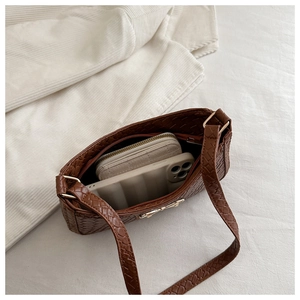 Internal view of the brown woven shoulder bag showing large capacity for phone and wallet