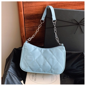 Detailed close-up of light blue quilted leather bag with silver chain and elegant strap