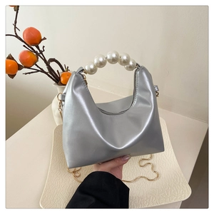 Silver metallic hobo bag with large white pearl handle and golden chain strap detail