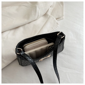 Detail of black woven bag showing interior space for wallet and phone with bow buckle