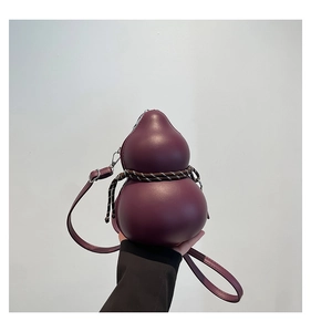 Gros plan du sac bandoulière bordeaux en forme de gourde avec corde et zip métallique